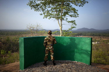 A police sentry looks out across the Dandakaranya forest while standing guard at the Counter-Terrorism & Jungle Warfare College in Kanker.