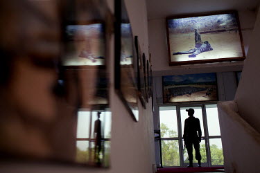 A police sentry standing guard outside of Brigadier B.K. Ponwar's office is reflected in photographs of training exercises hanging in the Counter-Terrorism & Jungle Warfare College in Kanker.
