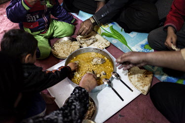 A family have a meal inside their tent. Domiz Refugee Camp run by UNHCR was established by local authorities in April 2012 to host the Syrian Kurds. The camp located 20 kms southeast of Dohuk city, in...