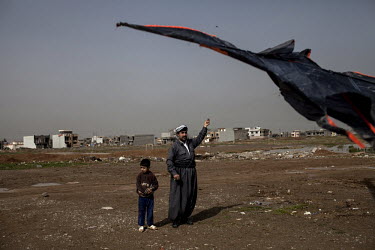 A father flies a kite with his son.