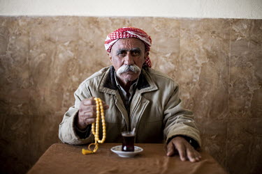 A Yazidi man holds prayer beads in a traditional cafe. The Yazidi are a Kurdish ethno religious group. They adhere to a branch of Yazdanism that blends elements of Mithraism, pre-Islamic Mesopotamian...