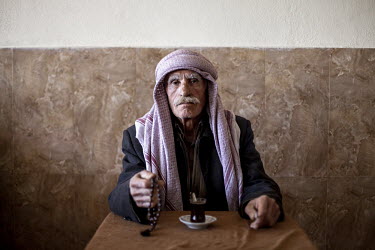 A Yazidi man holds prayer beads in a traditional cafe. The Yazidi are a Kurdish ethno religious group. They adhere to a branch of Yazdanism that blends elements of Mithraism, pre-Islamic Mesopotamian...