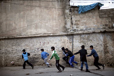 Boys play football on a street.
