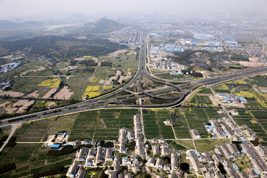 A complex road system and junction cuts through traditional fields and agricultural land.