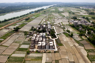Apartment blocks in the Shibuzhen area by the Yongjiang River, surrounded by agricultural land and fields.