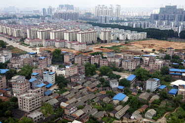 Old buildings and houses in the foreground contrasts with new apartment blocks in the background.