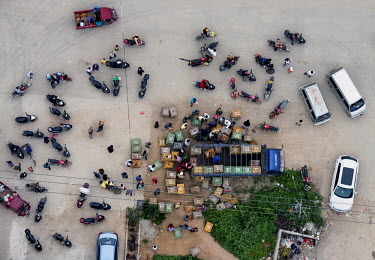 A poultry market in the city of Nanning. people park up their motorcycles =.