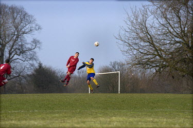 Two players jump to head the ball during an amateur game of football in Moor Park, Preston, Lancashire.
