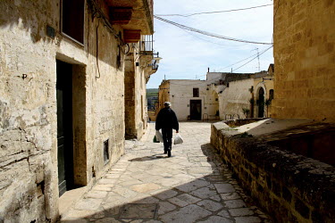 A man walks along a street in the old town of Matera.