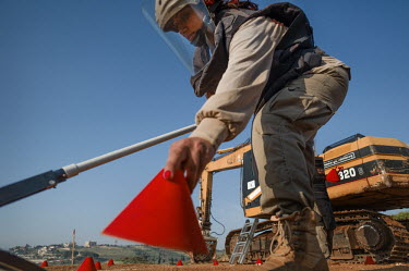 Fatima Bahmad, a deminer working for Mines Action Group (MAG), rapidly checks the ground with a detector and marks out a safe area with plastic cones during a medivac drill.