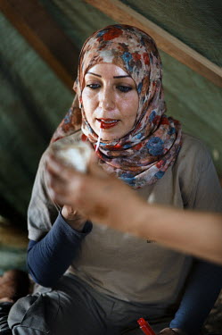 Amal Nader, a deminer working for Mines Action Group (MAG), takes notes during a debrief after a seession clearing mines.