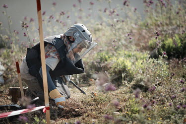 Amal Nader, a deminer working for Mines Action Group (MAG), uses her prodder to carefully investigate the soil after her detector signalled the presence of metal under the ground.