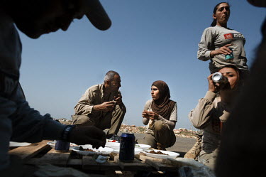 Deminers from the Mines Action Group's (MAG) Battle Area Clearance (BAC) team 3 eat a meal during a break from their work at a clearance site.