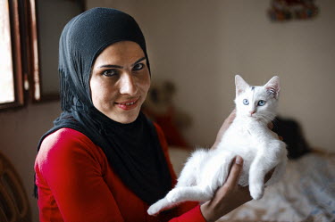 Layla Aboud, a deminer working for Mines Action Group (MAG), at home with her pet cat Si Si.