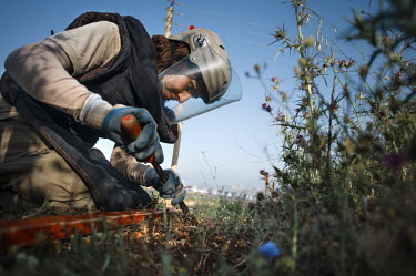 Layla Aboud, a deminer working for Mines Action Group (MAG), uses her prodder to carefully investigate the soil after her detector signalled the presence of metal under the ground.