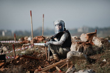 Layla Aboud, a deminer working for Mines Action Group (MAG), sits on ground at the site of a new monastery built on land she has helped clear of mines.