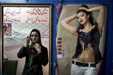Afghan parliamentary election candidate Galia Nooristani is seen in Kabul next to a poster of a model.