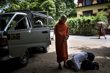 A supporter of U Wirathu, the spiritual leader of the Buddhist nationalist 969 Movement bows at his feet outside his quarters at the New Maesoeyin Monastery in Mandalay. U Wirathu is an abbot in the N...