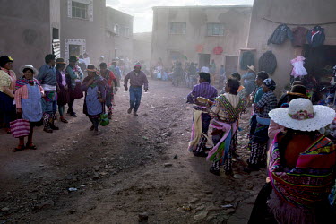 People walk down a back street in Macha during the <i>tinku</i> festival.   The people of Macha and surrounding communities carry on the pre-Columbian tradition of ritual fighting. The communities gat...