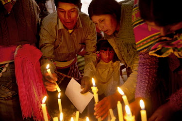 People take a break from the ritual fighting and attend mass in the church of Macha during the <i>tinku</i> festival.   The people of Macha and surrounding communities carry on the pre-Columbian tradi...