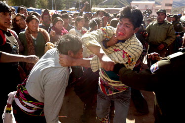 Two men punch each other during the ritual fighting in the plaza of Macha.   The people of Macha and surrounding communities carry on the pre-Columbian tradition of ritual fighting. The communities ga...