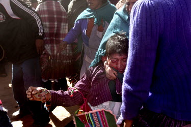 A woman pulls her injured man away during the ritual fighting in the plaza of Macha.   The people of Macha and surrounding communities carry on the pre-Columbian tradition of ritual fighting. The comm...