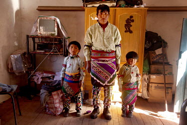 Senovio Suyo and his sons David, 6, and Ariel, 4, stand in his bedroom dressed in in traditional Tinku outfits before the fights in Macha.   The people of Macha and surrounding communities carry on th...