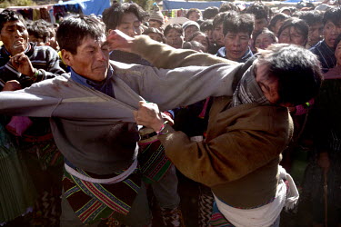 Two men punch each other during the ritual fighting in the plaza of Macha.   The people of Macha and surrounding communities carry on the pre-Columbian tradition of ritual fighting. The communities ga...