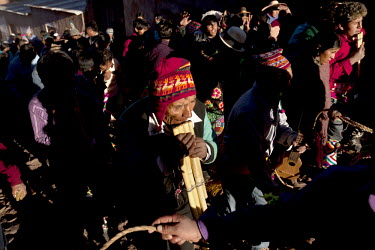 A man with a panflute plays traditional music as the people gather in the plaza of Macha during the <i>tinku</i> festival.   The people of Macha and surrounding communities carry on the pre-Columbian...