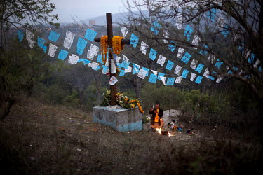 A man lights a candle and says prayers on his way to the top of Cruzco, a mountain that is sacred to people in the region, during La Fiestas de la Santa Cruz (Festival of the Holy Cross). The festival...