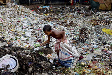 A boy collects recyclable items from among the piles of rubbish dumped along the banks of the Buriganga River. Everyday 1.5 million cubic metres of waste water from 7,000 industrial units in surroundi...