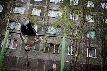 Alexander (16) and Arkadi (17) exercise on an exercise bar in front of a Soviet era apartment block in Murmansk.