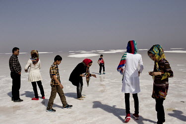 A family walk in the salt shallows of Lake Urmia, a salt lake in the province of West Azerbaijan. It is a popular destination as its salts and mineral rich muds are considered to have healing properti...