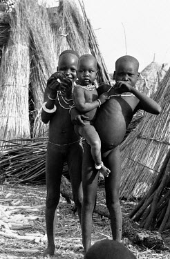 Nuer children in a cattle camp on the banks of the Baro River. They rub ash on their skin as protection against biting flies. The Nuer are traditionally cattle breeders and migrate, between their vill...