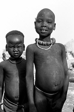 Nuer children in a cattle camp on the banks of the Baro River. They rub ash on their skin as protection against biting flies. The Nuer are traditionally cattle breeders and migrate, between their vill...