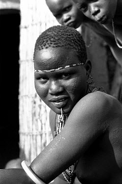 A Nuer woman in a cattle camp on the banks of the Baro River. The Nuer are traditionally cattle breeders and migrate between their villages where they live during summer to temporary cattle camps in w...