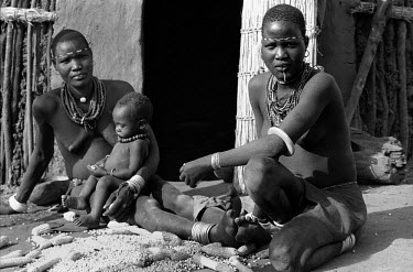 Nuer women with children in a cattle camp on the banks of the Baro River. They rub ash on their skin as protection against biting flies. The Nuer are traditionally cattle breeders and migrate between...