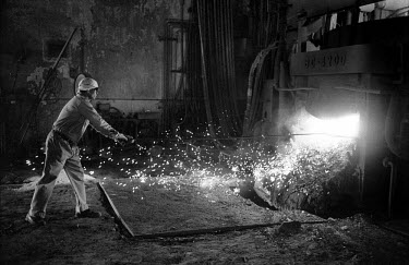 A worker moves a piece of metal being formed in a furnace at Tata Steel's Tayo plant. The facility produces plant, such as heavy rollers for paper mills.