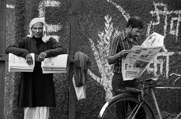 A newspaper vendor and customer at one of the entrance gates to the Tata Steel plant in Jamshedpur. This is the country's biggest and oldest steel works, employing some 26500 people.