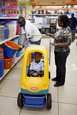 A couple and their son select plastic buckets from a large variety on offer in a supermarket in The Village Market which claims to be 'East Africa�s largest Shopping, Recreation and Entertainment dest...