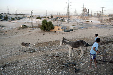 Children play next to a couple of donkeys in the unrecognised Bedouin village of Wadi el Na'am which stands next to an Israel Electric Corporation's power station and the Ramat Hovav hazardous waste d...