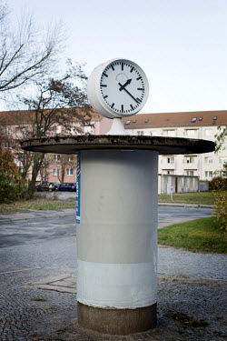 A clock mounted on a column on a street outside a socialist era apartment complex. Founded in 1950 around a steel and given the name 'Stalinstadt' ('Stalin City') in 1953 in honour of the Soviet Leade...