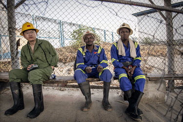 A Chinese supervisor waits with Zambian miners to go underground at the NFCA's (Non-Ferrous Company Africa) Chambishi copper mine. The NFCA, a Chinese company, owns and operates several mines and plan...
