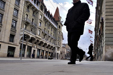 A man walks on the Corraterie, one of the city's principal banking streets. The UBS building is to their left.