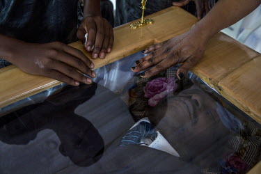 Relatives touch the coffin at the funeral of Judge Modeste Martineau Bria who was killed by Seleka fighters in Bangui. The murder of Bria led to an outpouring of public anger at the reign of fear impo...