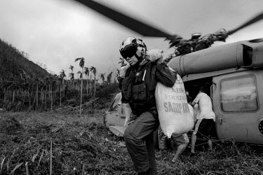 A member of an American helicopter crew helps to unload relief supplies for a remote village on Leyte island affected by the Typhoon. Typhoon Haiyan, or Typhoon Yolanda as it is known in the Philippin...
