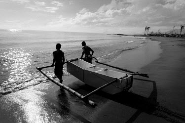 Two men pull a boat made out of an old refrigirator into the sea. Francis Kyle, a fisherman in Tanauan, noticed a floating fridge. He found a couple amongst the debris in the town and fasioned a small...