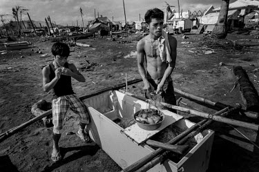 A man checks his catch next to a boat made out of an old refrigirator. Francis Kyle, a fisherman in Tanauan, noticed a floating fridge. He found a couple amongst the debris in the town and fasioned a...
