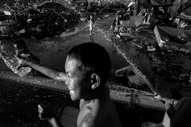 Children play at a water point among the debris and the ruins of houses in Tacloban. Typhoon Haiyan, or Typhoon Yolanda as it is known in the Philippines, was the deadliest typhoon to hit the Philippi...