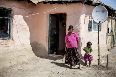 A woman with her daughter in front of their house in the Roma district of Frumusani.